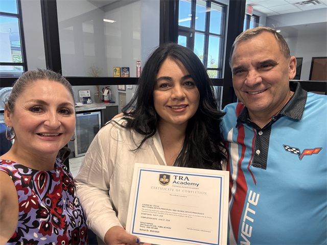 A TRA Academy student with their certificate of completion alongside instructors Nora Acosta and John Endres