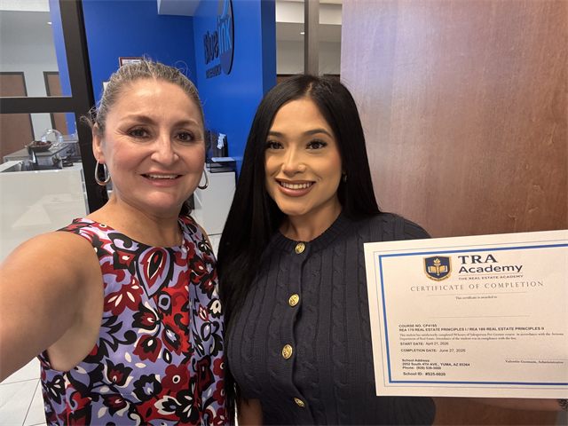 A TRA Academy student holding their certificate of completion with instructor Nora Acosta